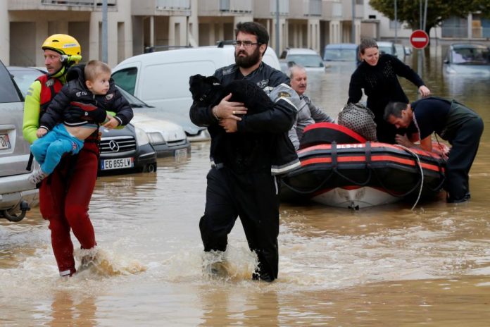 Rescue workers evacuate residents from a neighborhood after flash floods hit the southwestern Aude district of France after several months' worth of rain fell in just a few hours overnight, in Trebes